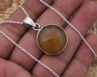 May include: A silver chain necklace with a round, yellow-brown gemstone pendant.