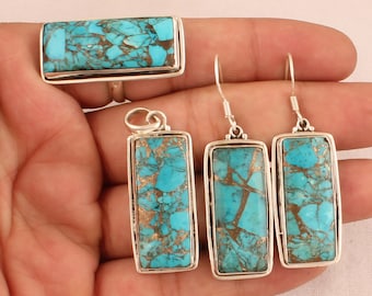 May include: A set of turquoise jewelry featuring a ring, pendant, and earrings. The turquoise stones are a vibrant blue with brown and gold accents. The jewelry is made of sterling silver.