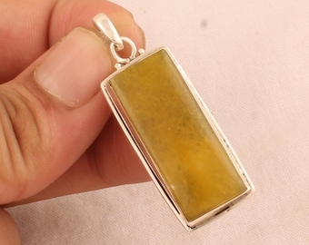 May include: A silver pendant with a rectangular yellow gemstone. The pendant is set in a silver frame and has a simple design.