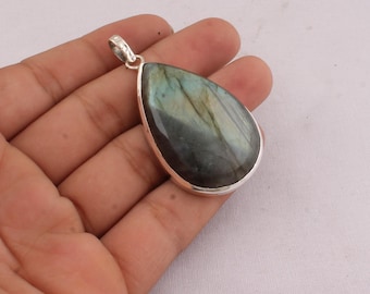 May include: A teardrop-shaped pendant with a silver-colored bezel. The gemstone has a mix of blue, green, and gray hues. The pendant is designed to be worn as a necklace. The gemstone is approximately 1.5 inches long.