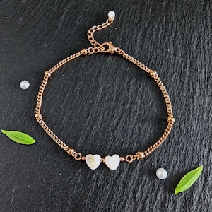 Puede incluir: Un delicado tobillo de cadena dorada con tres dijes en forma de corazón blanco. El tobillo tiene un cierre de langosta.