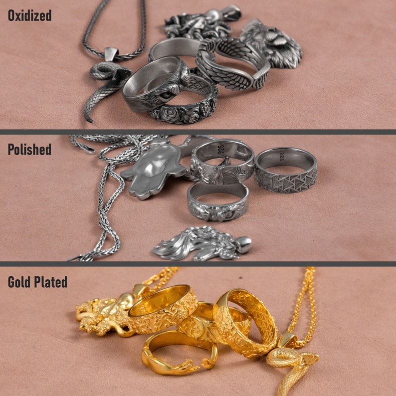 May include: Three rows of silver rings and necklaces with different finishes: oxidised, polished, and gold plated. The rings feature intricate designs, including a snake, a hand, and a wing.