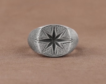May include: A silver ring with a textured, star-shaped design.