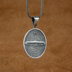 May include: Silver pendant with a textured oval shape and a silver chain. The pendant has the text "Customized Engraving" on it.
