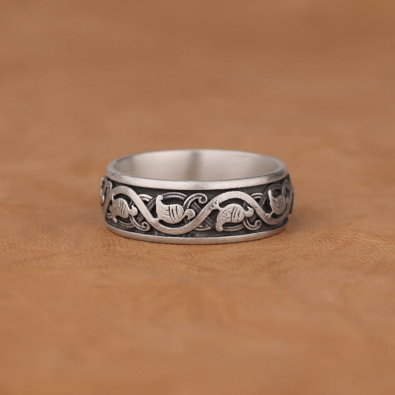 Puede incluir: Un anillo de plata con un dise&ntilde;o intrincado de enredaderas y hojas entrelazadas.
