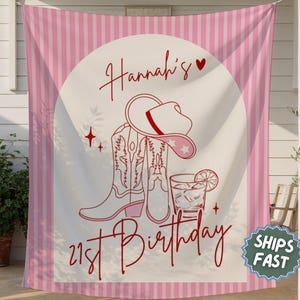 May include: Pink and white striped banner with a central design featuring a cowboy hat, boots, and a cocktail. The banner reads "Hannah's 21st Birthday" in a cursive font. The design is in red.