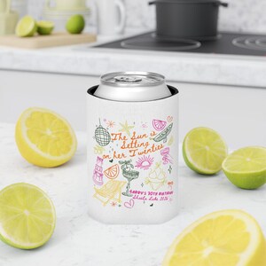May include: White can cooler with colorful illustrations and text that reads "The Sun is Setting on her Twenties." The design includes a disco ball, a cocktail, and a beach chair. The text "Gabby's 30th Birthday Shasta Lake 2016" is also present.