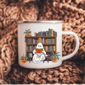 white camp enamel mug with silver rim, this ghost mug design has a cottagecore ghost reading a book with bookshelf and coffee mug, perfect gift for book lovers and a great ghost mug for a gothic friend.