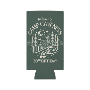 May include: A dark green can cooler with a white camping-themed design. The design includes the text "Welcome to Camp Caveness," a river, trees, a tent, and a campfire. The text "30th Birthday" is also included.