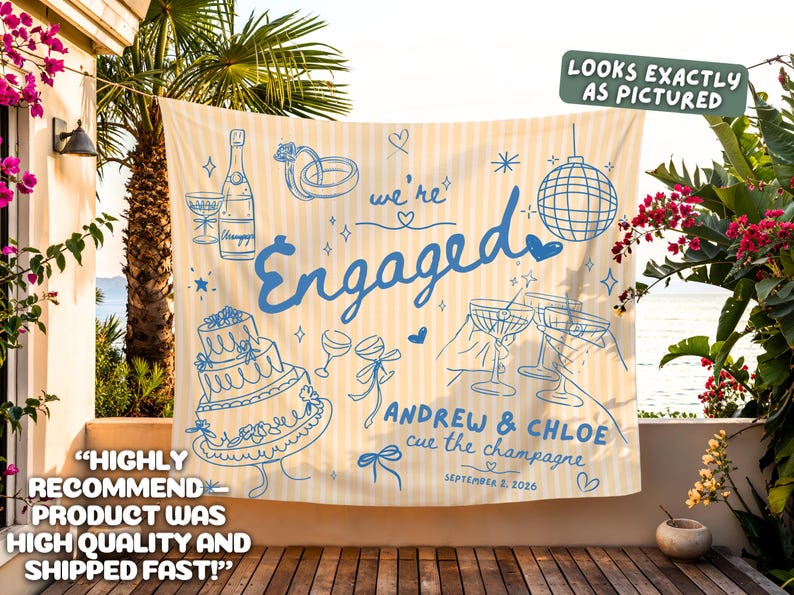 May include: A rectangular fabric banner with a light yellow and white vertical striped pattern. The banner features blue line art illustrations of a champagne bottle, a tiered cake, a disco ball, and cocktail glasses, with the text "we're Engaged", "ANDREW & CHLOE", "cue the champagne", and "SEPTEMBER 2, 2026".