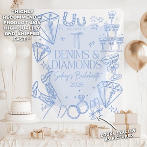May include: A light blue backdrop with the text "Denims & Diamonds" and "Sidney's Bachelorette 2026". The design includes diamonds, cowboy boots, champagne glasses, and rings. The backdrop is set up for a party.