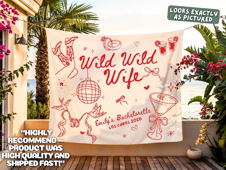 May include: A cream-colored banner with red illustrations and text. The banner reads "Wild Wild Wife" with additional text "Emily's Bachelorette Los Cabos 2026". The design includes images of cowboy boots, a disco ball, and cocktails.