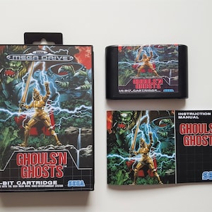 May include: A Sega Mega Drive game cartridge and instruction manual for the game "Ghoul's 'n Ghosts". The game cartridge is black with a red label that says "Ghoul's 'n Ghosts" and "16-bit Cartridge". The instruction manual is black with a red label that says "Ghoul's 'n Ghosts" and "Instruction Manual".