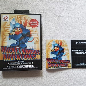 May include: A Sega Genesis game cartridge for Rocket Knight Adventures featuring Sparkster, a blue and orange anthropomorphic rabbit knight. The game cartridge is in its original box with a matching instruction manual.