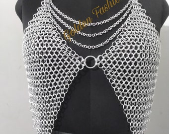 May include: Silver chainmail top with a V-shaped neckline and multiple chain straps. The top is displayed on a black mannequin.