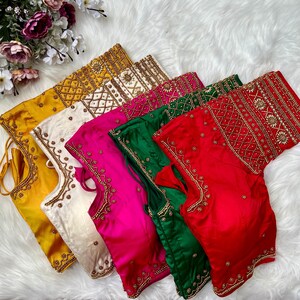 May include: Six embroidered silk blouses in various colors, including yellow, white, pink, green, and red. Each blouse features intricate gold beading and a unique design.