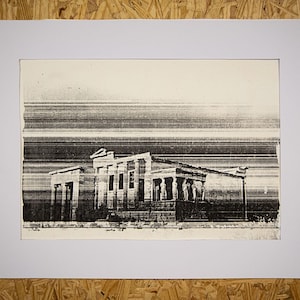 May include: Black and white print of a classical building with columns and a detailed facade, set against a striped background. The artwork is framed in a white mat, presented on a wooden surface.