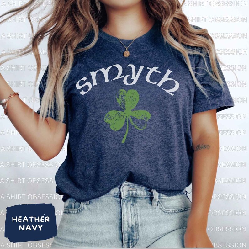 May include: A heather navy blue t-shirt with a white graphic of a shamrock and the word "smyth" above it.