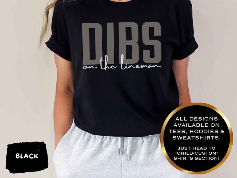 May include: Black t-shirt with the text "DIBS on the lineman" in grey and white. The shirt is worn with grey sweatpants. The image also states that all designs are available on tees, hoodies, and sweatshirts.