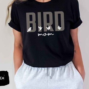 May include: Black t-shirt with the text "BIRD mom" in gray letters and a row of small white birds above the text.
