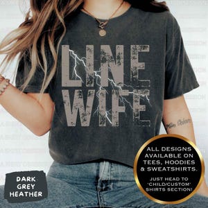 May include: A dark heather grey t-shirt with the text "LINE WIFE" in white with a lightning bolt graphic. The text is distressed and has a vintage look. All designs are available on tees, hoodies, and sweatshirts. Just head to the 'Child/Custom' shirts section.