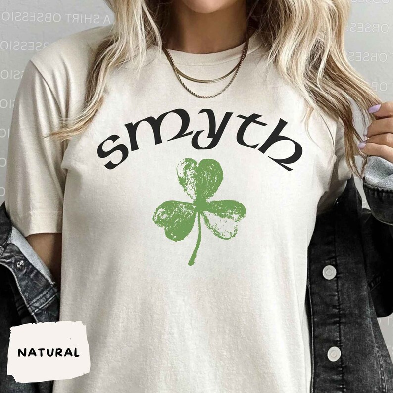 May include: A white t-shirt with a green shamrock and the word "smyth" in black lettering.