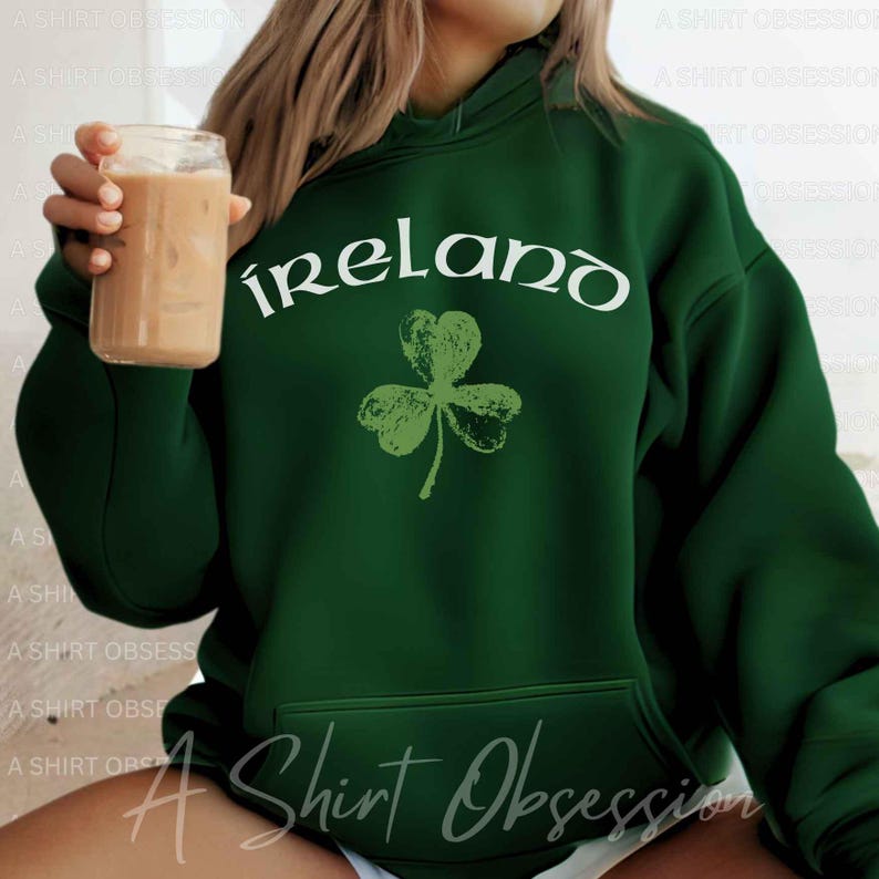 May include: Green hooded sweatshirt with a white graphic of a shamrock and the word "ireland" in a stylized font.