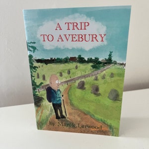 May include: A book cover with a cartoon illustration of a person walking on a path in a green field. The title of the book is "A Trip to Avebury" by Marek Larwood.