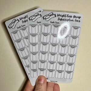 May include: A set of three weight-loss group subscription fee stickers. Each sticker features a scale icon and the text "Each Icon". The stickers are printed on white paper with black ink.