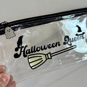 Cartera de vinilo transparente con cremallera de la Reina de Halloween. Detalle de vinilo brillante con un palo de escoba. Dije de fantasma. Compatible con la mayoría de los billetes y rastreadores de ahorro.