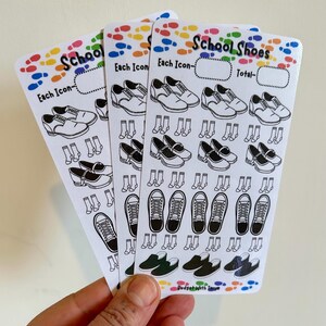 Puede incluir: Tres hojas de pegatinas blancas con ilustraciones en blanco y negro de zapatos escolares y calcetines. El texto "School Shoes" y "Each Icon" está impreso en las pegatinas. Huellas de colores bordean la parte superior e inferior.