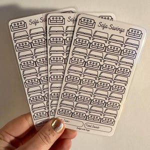 Puede incluir: Tres hojas de papel adhesivo transparente con dibujos de sofás en contorno negro. Las hojas están etiquetadas "Sofa Savings" y "Each Icon - Budget With Taryn".