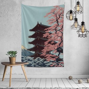 May include: A tapestry depicting a Japanese-style illustration of a pagoda with a cherry blossom tree in the foreground and Mount Fuji in the background. The pagoda is red and the cherry blossoms are pink.