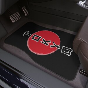May include: Black car floor mat with a red circle and the word "Tokyo" written in Japanese characters.
