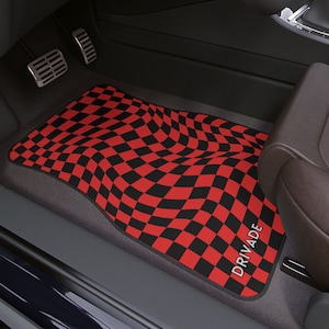 May include: Red and black checkered car floor mat with the word "DRIVADE" printed on it.