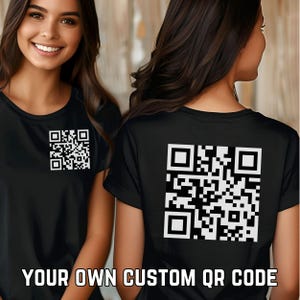 Könnte beinhalten: Zwei schwarze T-Shirts mit einem weißen QR-Code, der auf der Vorder- und Rückseite aufgedruckt ist. Der Text "YOUR OWN CUSTOM QR CODE" ist unter dem QR-Code auf der Vorderseite des Shirts aufgedruckt.