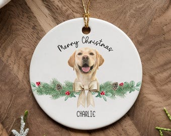 May include: White ceramic Christmas ornament with a watercolor illustration of a golden retriever dog wearing a brown bow. The ornament has the text "Merry Christmas" and the name "Charlie" printed on it.