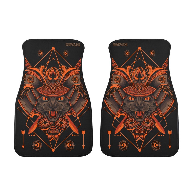 May include: A pair of black car floor mats with an orange samurai cat design. The design features a cat wearing a samurai helmet with swords and a geometric pattern.