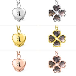 May include: Three silver, gold, and rose gold necklaces with heart and four-leaf clover lockets. The heart lockets have the letter "A" engraved on them. The four-leaf clover lockets have a small photo in each leaf.