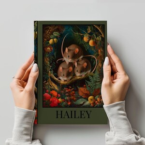 Pode incluir: Uma capa de livro verde com uma pintura de três ratos marrons em um cenário de floresta. Os ratos estão sentados em um galho com folhas e flores. A capa do livro tem a palavra "HAILEY" impressa em letras brancas.