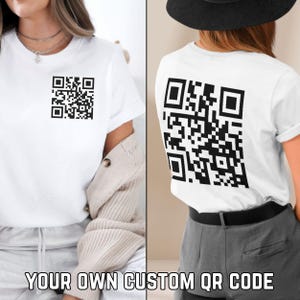 May include: White t-shirt with a black and white QR code printed on the front and back. "YOUR OWN CUSTOM QR CODE" is printed below the image.