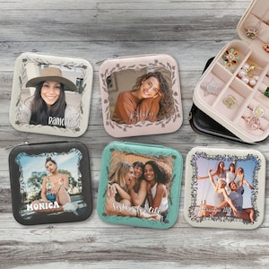 May include: Square jewelry cases with personalized photos. The cases are in various colors, including cream, pink, black, and teal. Each case features a framed photo and a name. One case says "Sisters for life" and another says "Autumn 2018".