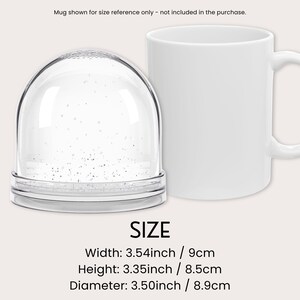 Może przedstawiać: Przezroczysta kula śnieżna w kształcie kopuły ze srebrnym brokatem w środku, na przezroczystej podstawie. Obok biały kubek dla odniesienia. Kula śnieżna ma 9 cm szerokości, 8,5 cm wysokości i 8,9 cm średnicy.