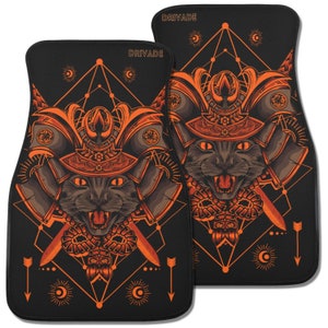 May include: A pair of black car floor mats with an orange geometric design featuring a cat wearing a samurai helmet. The mats have the word "Drivade" printed on them.