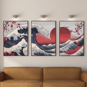 May include: A set of three framed prints depicting a traditional Japanese wave design with a red sun and cherry blossoms. The prints are in black frames and have a white background.