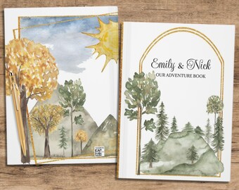 May include: Two white covers for a personalized adventure book. The covers feature watercolor illustrations of a forest with mountains and a sun in the sky. The text on the cover reads "Emily & Nick Our Adventure Book".