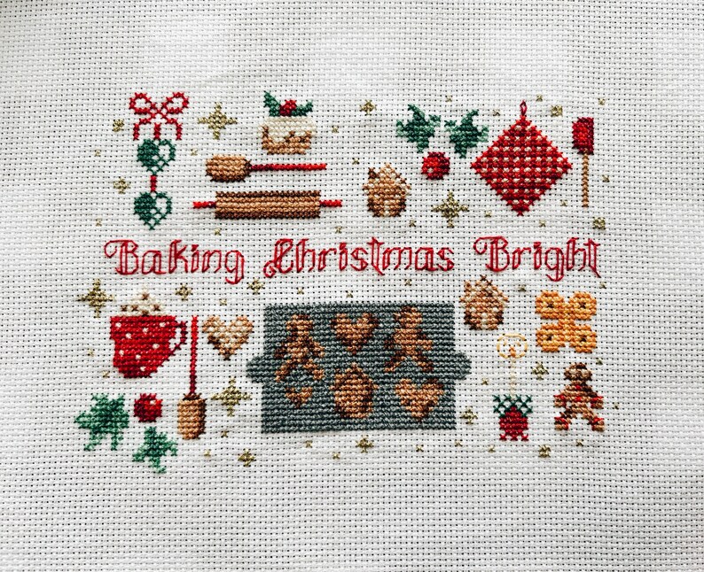 May include: Cross-stitch pattern featuring a festive Christmas baking scene with the text "Baking Christmas Bright". The design includes a gingerbread house, cookies, a rolling pin, a mug of hot chocolate, and other holiday baking elements.