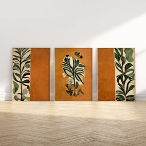 May include: Three framed prints with a minimalist design featuring stylized green plants on a burnt orange background.