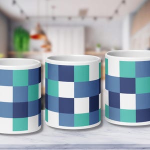 May include: Three white ceramic mugs with a blue, green, and white checkered pattern.