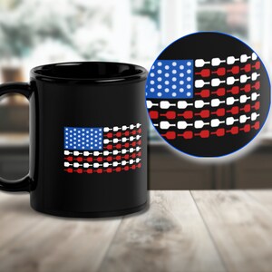 Könnte beinhalten: Schwarze Keramik-Kaffeetasse mit einem amerikanischen Flaggen-Design in Weiß und Rot, das aus Weinflaschensilhouetten besteht. Die Flagge hat weiße Sterne auf einem blauen Feld.